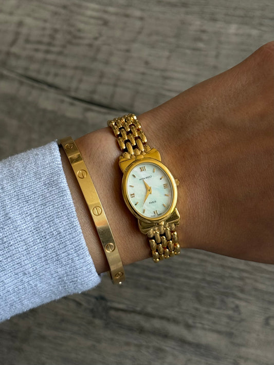 Nina Ricci Gold Toned Watch with Bow Bezel Set