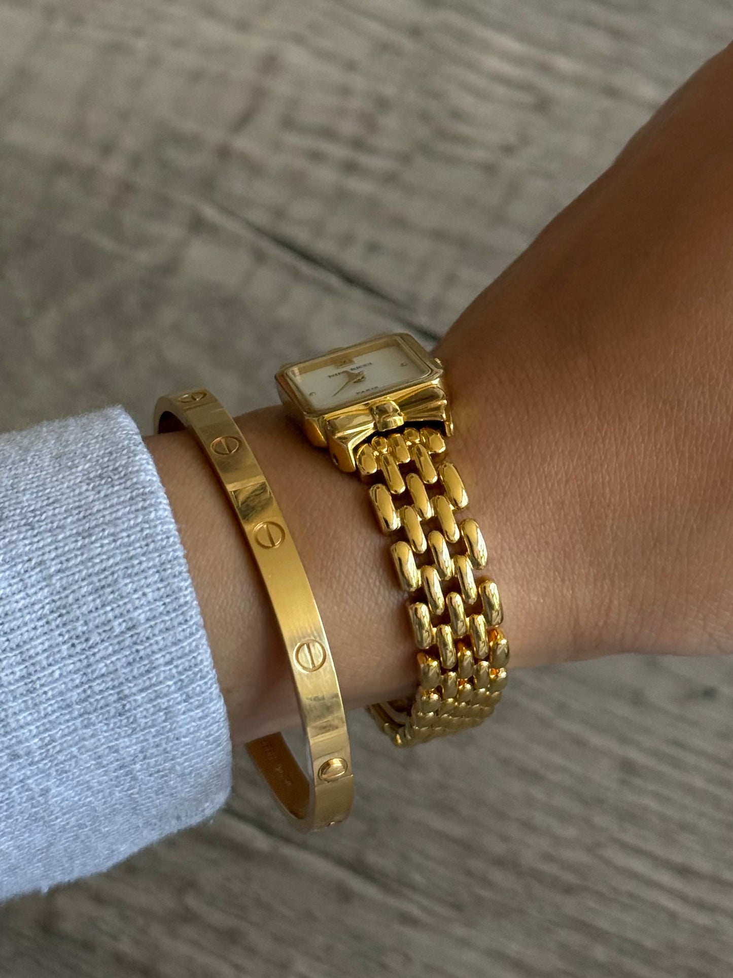 Nina Ricci Gold Toned Watch with Bow Bezel Set