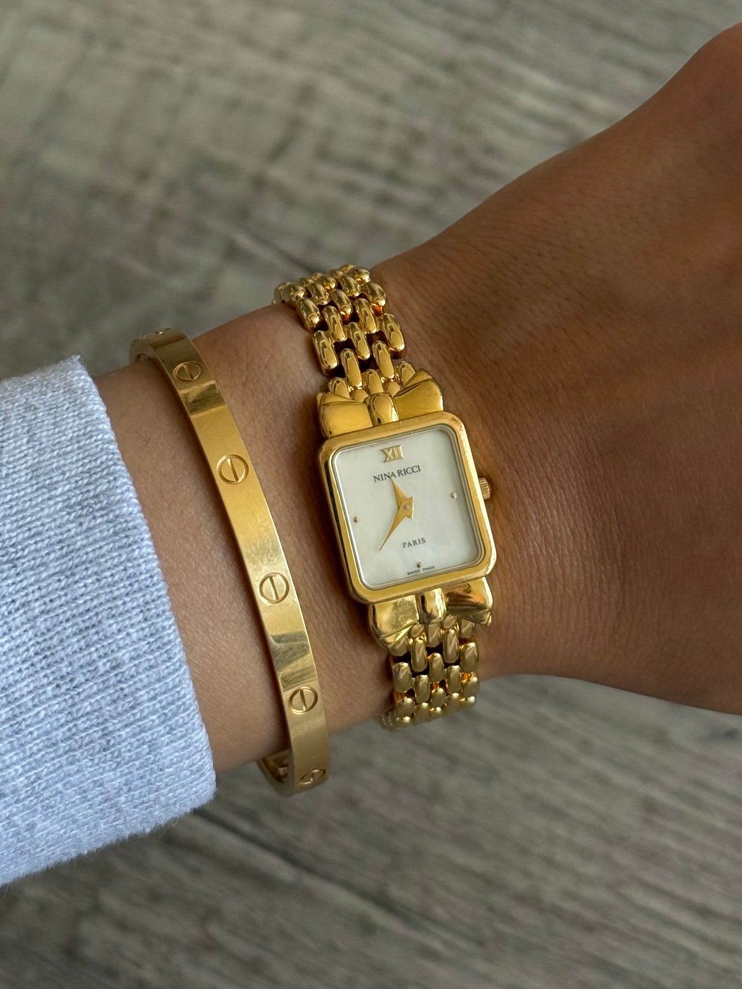 Nina Ricci Gold Toned Watch with Bow Bezel Set
